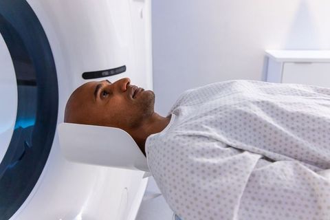 African american man undergoing mri scan lying on high-tech scanner table in hospital