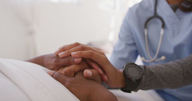 Doctor holding the hand of a patient, showing support and comfort in a hospital setting. Suitable for use in healthcare-related content, promotional materials for medical services, and illustrating themes of compassion, support, and patient care.