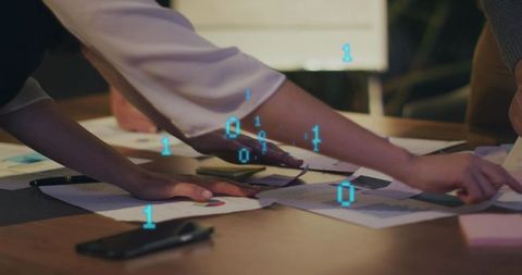 Team collaborating over data reports showing binary digital overlay, charts, analytics