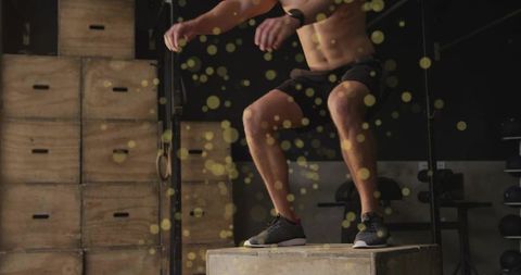 Shirtless male athlete balancing on plyo box in industrial gym strength and speed training