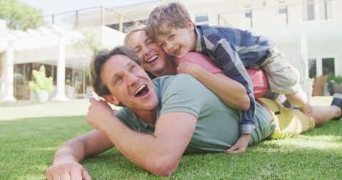 Joyful Family Relaxing on Sunny Lawn Embracing Each Other