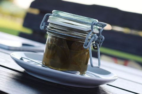 Glass jar of pickled vegetables on white plate outdoors