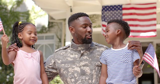 Happy african american daughter and son with flags welcoming home soldier father. Military service, returning home, celebration, patriotism, childhood, fatherhood and family, unaltered