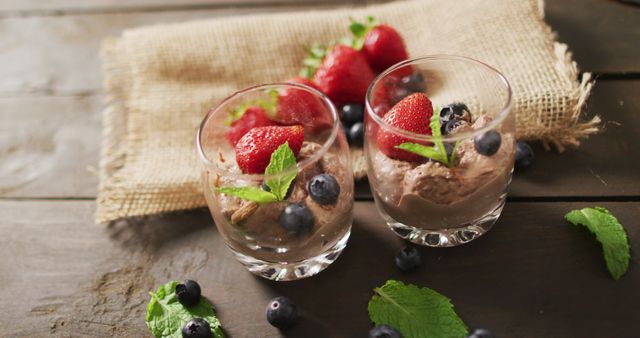 Image of chocolate pudding with strawberries and bluberries on a wooden surface. party food and savoury snacks.