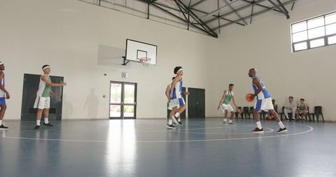 Intensity of a young basketball team in action on indoor court