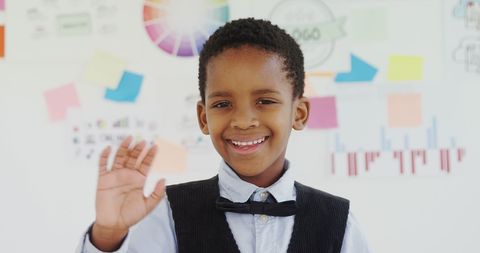 Confident Child in Business Outfit Waving in Office Environment