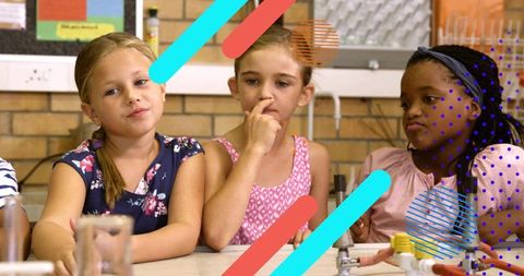 Primary students conducting science experiment with glassware and tubing showing teamwork