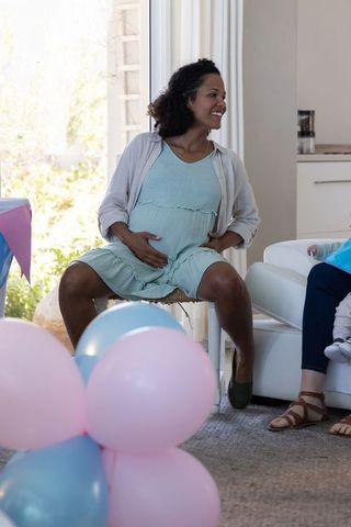 Joyful maternity celebration with friends and pastel balloons