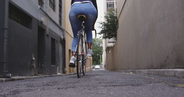 Cyclist riding through urban alleyway with buildings - Download Free Stock Images Pikwizard.com