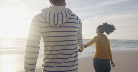 Joyful Couple Running Holding Hands on Sunny Beach