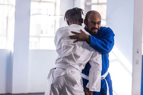 African american men practicing grappling arts in training studio