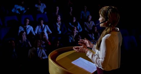 Confident female entrepreneur presenting at business conference