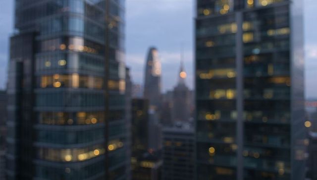 Blurry evening skyline with illuminated skyscraper windows