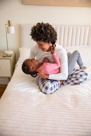 Joyful African American Mother and Daughter Bonding in Cozy Bedroom