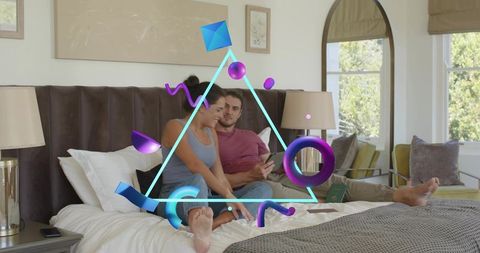 Couple Using Smartphone Showing Augmented Reality Graphics on Bed in Modern Bedroom Scene