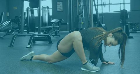 Athletic Woman Stretching in Modern Gym Facility