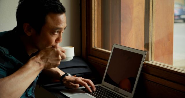 Focused Man Working on Laptop in Coffee Shop by Window - Download Free Stock Images Pikwizard.com