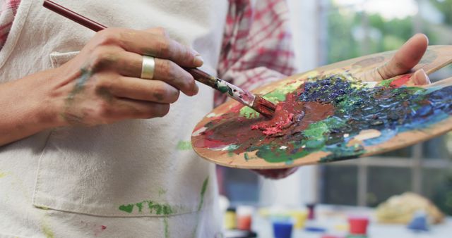 Close-up of Artist Mixing Vibrant Paint on Palette With Brush - Download Free Stock Images Pikwizard.com