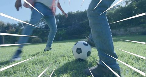 Backyard soccer action focusing on feet and ball with motion lines and sunlit grass