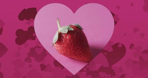 this composition features a ripe strawberry placed in a heart shape against a vibrant pink background, combining themes of love and health. perfect for valentine's day promotions, healthy living advertisements, romantic-themed content, or organic food products. the vivid colors emphasize emotional appeal and wellness connections.