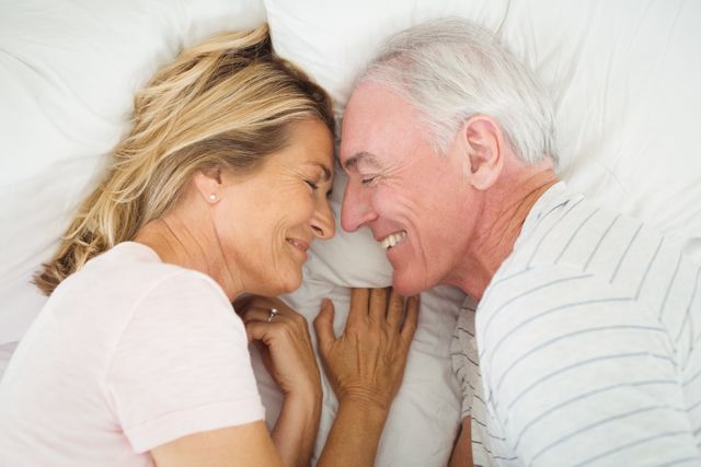 Happy senior couple lying on bed - Download Free Stock Photos Pikwizard.com