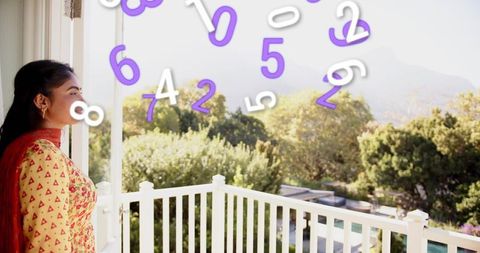 Woman in yellow kurta standing on balcony overlooking valley with floating purple numbers
