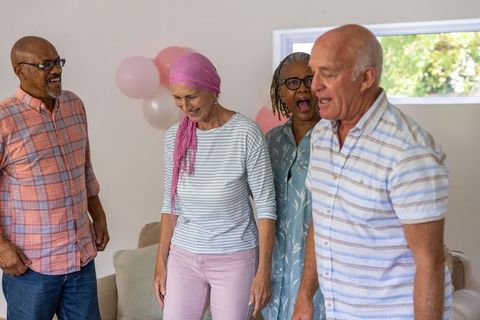 Diverse senior friends laughing together in joyful home celebration