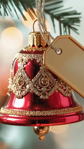 Vertical video featuring pulsing lights illuminating red bell ornament on pine branch