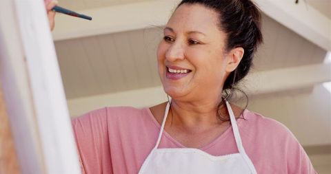 Woman enjoying painting project with enthusiasm and creativity