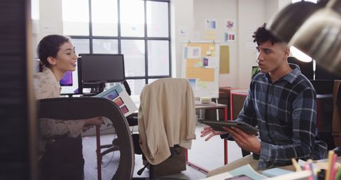 Diverse Colleagues Discussing Work with Tablet in Modern Office