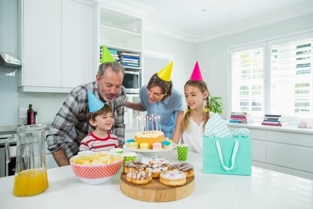 Family celebrating their sons birthday in kitchen at home