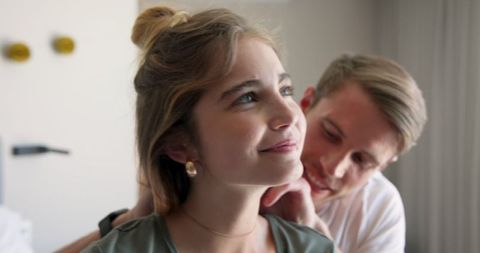 Couple Sharing Tender Moment as Man Helps Woman with Necklace