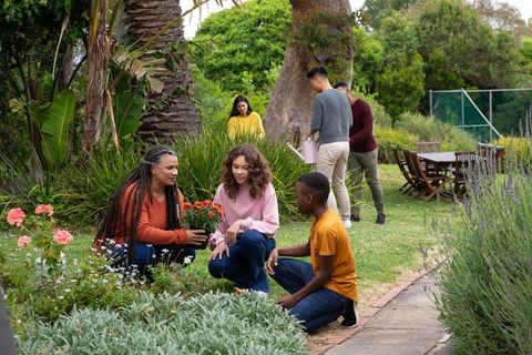 Diverse Family Enjoying Gardening Together in Lush Backyard