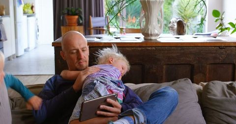Father and Children Bonding Over Tablet in Cozy Living Room