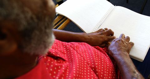 Blind Seniorman Reading Braille Book, Interior Seated Position