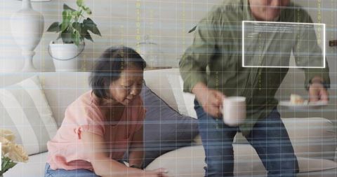 Couple Rearranging Sofa Cushions While Serving Coffee with Digital Data Overlay