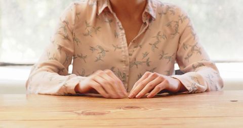 Businesswoman Tapping Fingers on Desk in Anticipation During Meeting