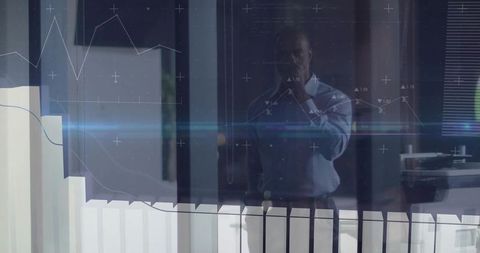 Businessman analyzing digital graphs behind glass partition