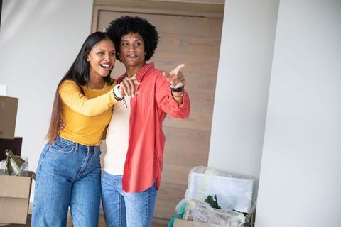 Couple smiling in new home with boxes signifying new beginnings