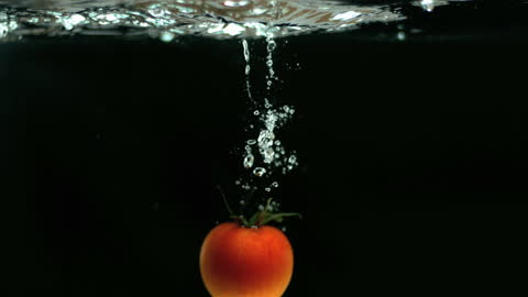 Fresh Tomato Dropping Into Clear Water Splashing