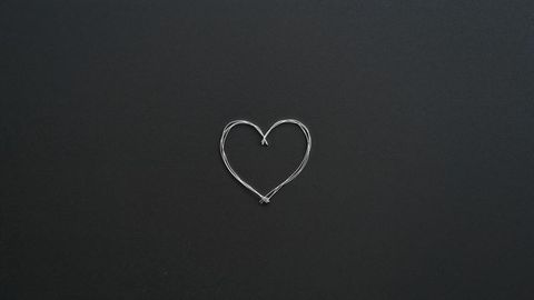 Silver Wire Heart Shape on Matte Black Surface Top View