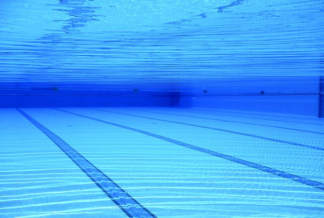 Image shows underwater view of swimming pool with distinct blue lines on the floor. Ideal for illustrating outdoor activities, swimming sports, aquatic exercises, refreshing water themes, and fitness-related content.