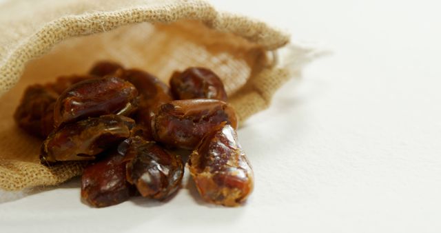 Close-up of dates spilling out of sack on white surface 4K 4k - Download Free Stock Photos Pikwizard.com