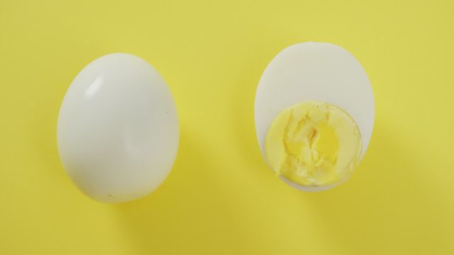 This vibrant video captures the simplicity of a hard boiled egg half alongside a whole egg against a bold yellow background. Ideal for culinary and food blogs, nutrition articles, and healthy eating campaigns. The clean, minimalistic setup emphasizes the eggs' natural features and is also suitable for Easter-themed projects and menus.