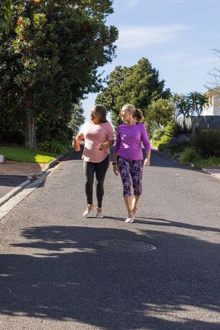 Diverse Female Friends Walking for Fitness in Suburban Street