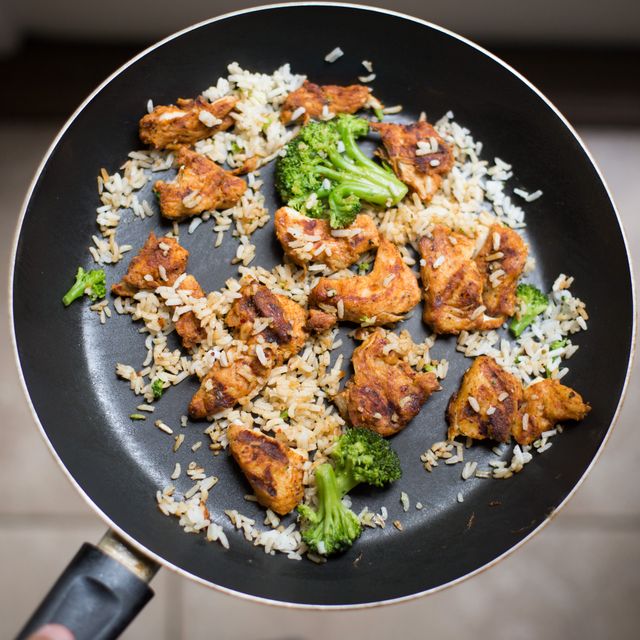 Close-up of chicken and vegetable stir fry in black frying pan. Ideal for content on healthy eating, home cooking, recipes, and meal preparation. Perfect for illustrating blogs, social media posts, or articles about balanced diets and nutritious meals.