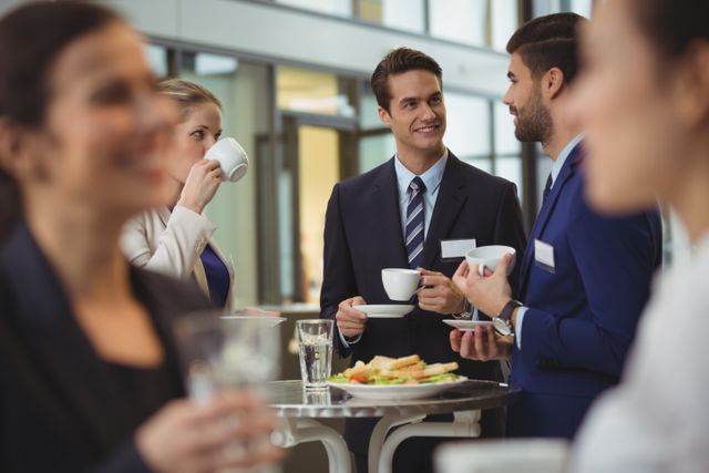 Businesspeople interacting with each other while having coffee - Download Free Stock Photos Pikwizard.com