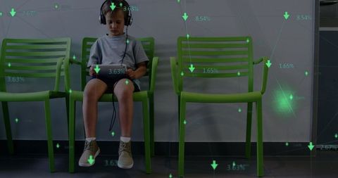 Young Boy Using Tablet with Headphones in Classroom Sitting
