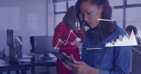 Businesswoman analyzing financial data with smartphone in modern office