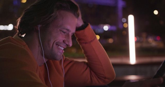 Man Smiling During Video Call at Night in Urban Landscape - Download Free Stock Images Pikwizard.com